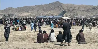  ?? SHEKIB RAHMANI ?? Hundreds of Afghans desperate to escape Taliban rule have been gathering along the barricaded perimeter at the internatio­nal airport in Kabul. A U.S. Air Force C-17 transport plane waits on the runway for evacuees.