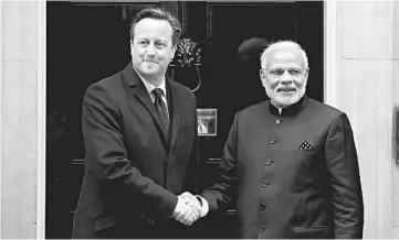  ??  ?? Modi (right) being greeted by Cameron outside 10 Downing Street. —