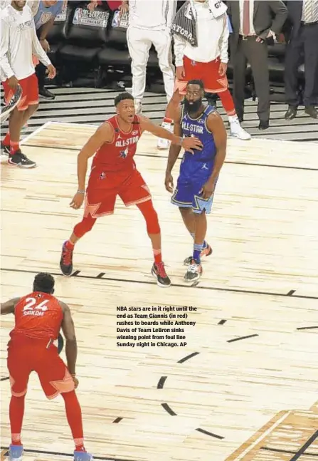  ??  ?? NBA stars are in it right until the end as Team Giannis (in red) rushes to boards while Anthony Davis of Team LeBron sinks winning point from foul line Sunday night in Chicago. AP