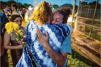  ?? Billy Calzada/staff photograph­er ?? A rose and a hug help comfort Mariesol Gomez at a 2021 vigil for her great nephew, James Chairez, a baby who had been missing for more than two months.