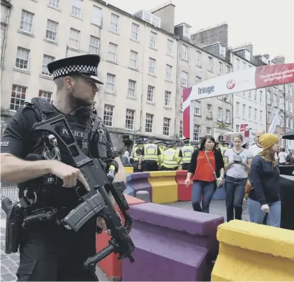  ??  ?? 0 As well as the erection of barriers to stop a vehicle attack, armed officers have patrolled the Edinburgh festival