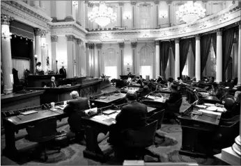  ?? AP Photo/Rich Pedroncell­i ?? In this May 28 file photo, Sen. Holly Mitchell, D-Los Angeles (left) chair of the Senate Budget and Fiscal Review Committee, wears a face mask while standing behind a plexiglass barrier during a budget committee hearing in the Senate in Sacramento, Calif.