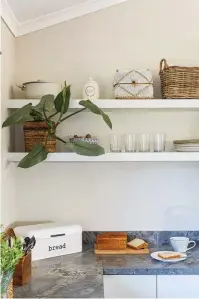  ??  ?? The house is filled with plants that add to the indoor-outdoor connection. Open shelving
(below) allows practical items to double as décor in the kitchen and rattan pendants, part of the extensive range imported by 8 Degrees South, provide task lighting above the island (right).