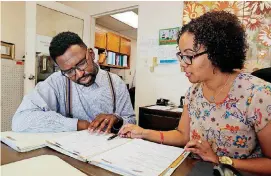  ?? [PHOTO BY PAUL HELLSTERN, THE OKLAHOMAN] ?? William Stubbs, the charter school director for Oklahoma City Public Schools, works with Harper Charter School’s office manager Kristin Embery.