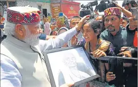  ?? HT PHOTO ?? PM Narendra Modi accepts a portrait of his mother, made by a local artist, in Shimla.