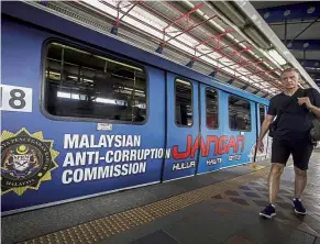  ?? — Bernama ?? New initiative: A man walking past a train with an MACC painted message at the Bank Rakyat Bangsar LRT station.