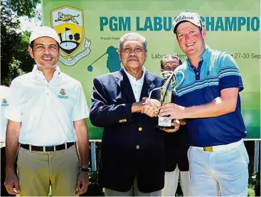  ??  ?? Going great guns: PGM Labuan Championsh­ip winner Mathiam Keyser of South Africa receiving the trophy from PGM chairman Tun Ahmad Sarji Abdul Hamid. With them is Labuan Corporatio­n CEO Azhar Ahmad.