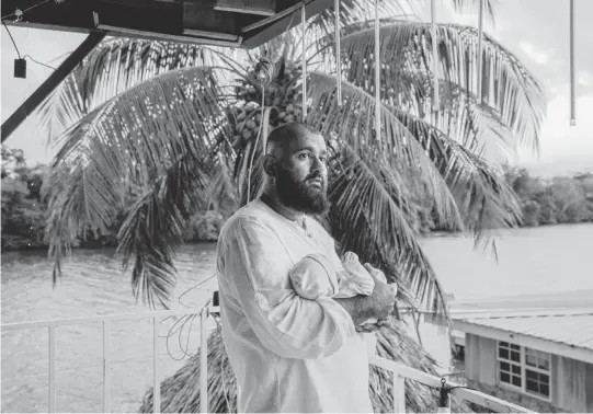  ?? NATALIE KEYSSAR NYT ?? Majid Khan holds his newborn son at a restaurant in Belize City, Belize, where his family broke their Ramadan fast in March. Khan joined al-Qaida after Sept. 11, 2001, and was a courier. He was released from the U.S. prison at Guantánamo Bay when Belize allowed him to resettle.