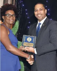  ??  ?? Patricia Tomlinson, general manager of JDF Co-operative Credit Union, accepting the Credit Union of the Year Award for large credit unions from Robin Levy, JCCUL’s Group CEO.