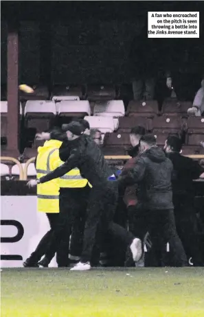  ?? ?? A fan who encroached on the pitch is seen throwing a bottle into the Jinks Avenue stand.