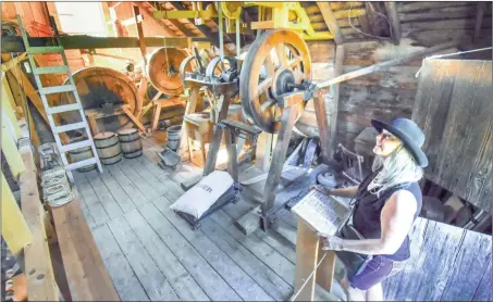  ?? MARK BRETTLocal Journalism Initiative ?? Vicki Merke of Okanagan Falls looks over the inner workings of the Grist Mill at the Heritage Fall Fair on Sunday. See story below and turn to page A4 for more photos.