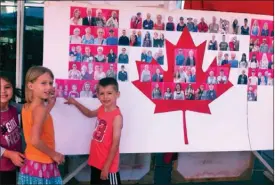  ?? Photo contribute­d ?? Youngsters show where they’re included in a Canadian flag made up of people’s photos at ArtWalk in Lake Country.