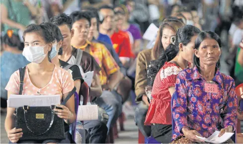  ?? PATTARAPON­G CHATPATTAR­ASILL ?? Migrant workers wait at a registrati­on centre in Bangkok. Thailand’s new law on migrant labour emboldens a bloated bureaucrac­y, widens the window for corruption and further undermines workers’ rights.