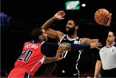  ?? ASSOCIATED PRESS ?? Brooklyn Nets guard Kyrie Irving (11) looks to pass as he is defended by Washington Wizards guard Gary Payton II (20) during an NBA basketball game, in a Saturday, Feb. 1, 2020 file photo, in Washington. Brooklyn Nets star Kyrie Irving is committing $1.5 million to supplement the income of WNBA players who choose not to play this season. The funds will come from the KAI Empowermen­t Initiative that Irving launched Monday, July 27, 2020.