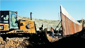  ?? — Reuters photo ?? File photo shows workers on the US side, working on the border wall between Mexico and the US, as seen from Tijuana, Mexico.