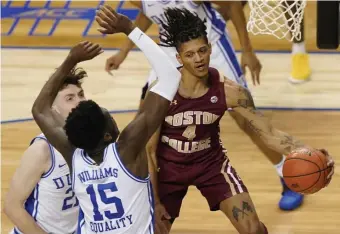  ?? AP PhOTOs ?? FLYING HOME: Boston College guard Makai Ashton-Langford drives around Duke center Mark Williams and forward Matthew Hurt during the second half of an ACC tournament game in Greensboro, N.C., on Tuesday. Below, Duke forward Wendell Moore Jr. loses control of the ball as he is fouled by Ashton-Langford.