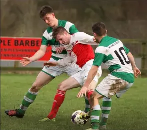  ??  ?? James Peare of Moyne tries to squeeze past Ian Sinnott and Eamonn O’Brien.