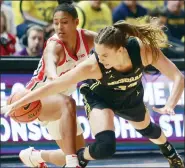  ?? PAUL VERNON — THE ASSOCIATED PRESS ?? Ohio State’s Taylor Thierry, left, and Michigan’s Emily Kiser reach for a loose ball during the Wolverines’ loss on Saturday. Michigan stayed at No. 14in the latest Top 25.