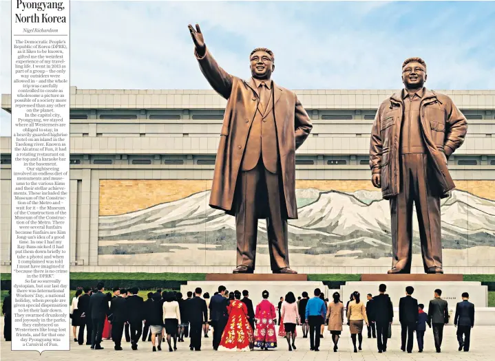  ?? ?? i Power to the people: 65ft-high statues of Kim Il Sung, founder of North Korea, and his son Kim Jong Il dwarf the crowd at the Mansu Hill Grand Monument in the capital Pyongyang. Nigel Richardson stayed in a heavily guarded highrise hotel known as ‘the Alcatraz of Fun’