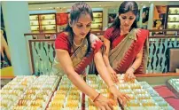  ?? — AFP ?? Salesperso­ns arrange gold bangles at a store in Ahmedabad.