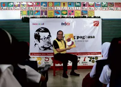  ?? LYN RILLON ?? THE READER President Aquino shares a children’s story before an audience of Grade 4 pupils in Quezon City on Tuesday in line with the government’s observance of National Reading Month.