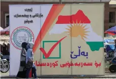  ?? Reuters ?? Iraqis walk past banners supporting the referendum for independen­ce for Kurdistan in Erbil, yesterday