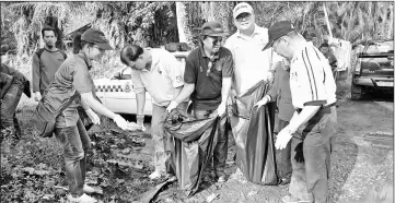  ??  ?? Ting (front, second left) and Yii (third right) help other volunteers during the ‘gotong-royong’.