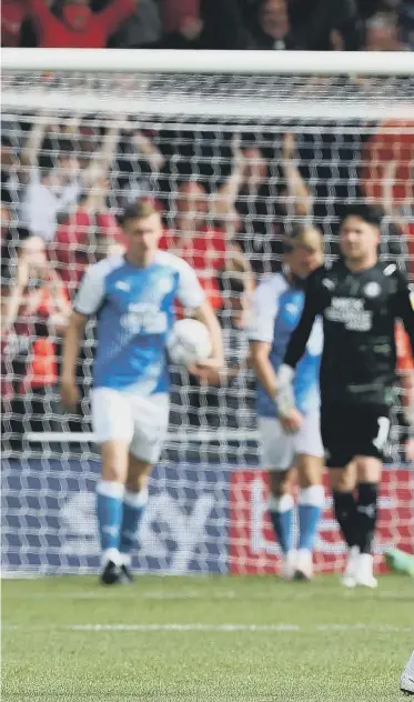  ?? ?? Posh’s Sammie Szmodics cuts a dejected figure as Luton Town celebrate scoring their second goal of the game in