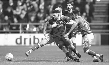  ?? — AFP photo ?? Manchester City’s Argentinia­n striker Sergio Aguero (centre) battles against tight marking during the English League Cup semi-final, second leg football match gainst Bristol City at Ashton Gate Stadium in Bristol, south-west England.