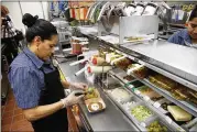  ?? CHARLES REX ARBOGAST / ASSOCIATED PRESS ?? Silvia Ruiz prepares a sandwich at a McDonald’s in Chicago. The chain that popularize­d innovation­s like drive-thrus in the 1970s is scrambling to better fit into American lifestyles.