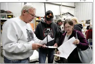  ?? (AP/Nati Harnik) ?? Richard Apking (left) and Debbie Johnson examine documents last fall after a town hall meeting in Winslow, Neb., during which relocating the village was discussed. More photos at arkansason­line. com/1229winslo­w/.