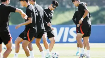  ?? Yonhap ?? Son Heung-min, in black head mask, practices passing with teammate Kim Min-jae, Wednesday, in their final training held at Al Egla Training Facility in Doha, Wednesday, one day ahead of their Group H match against Uruguay.