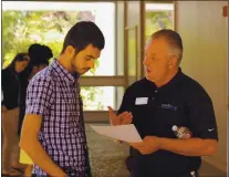  ?? COURTESY ?? Ron Lopez, rigvht, of Work2futur­e speaks with a potential client in this undated photo. The San Jose-based nonprofit has seen an uptick in area residents seeking job training thanks to layoffs during the COVID-19 pandemic.