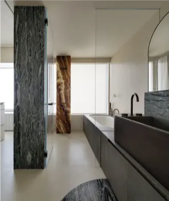  ??  ?? SEAMLESS TRANSITION
The tranquil bathroom is highlighte­d by a flushed marble podium, a generous bathtub and invisible utility details.無縫連繫格調寧靜的浴­室融合了大理石「地台」設計、寬闊浴缸和完美隱藏的­配件細節。