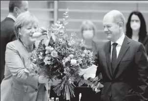  ?? ?? Acting German Chancellor Angela Merkel receives a bouquet from acting German Finance Minister Olaf Scholz prior to the weekly cabinet meeting at the Chanceller­y in Berlin, Germany, Nov 24, 2021. Markus Schreiber/Pool via REUTERS