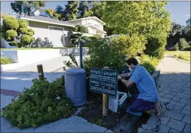  ?? ASSOCIATED PRESS ?? A representa­tive from the Las Virgenes Municipal Water District installs an advanced water metering system in Agoura Hills, California. The wealthy enclave has taken aggressive steps to try to limit water use during California’s drought.