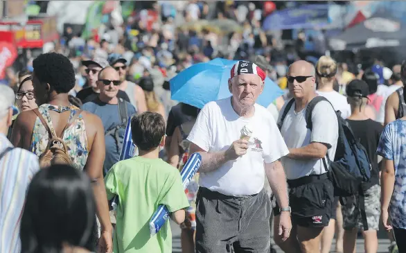  ?? NICK PROCAYLO ?? Fair-goers enjoy the warm temperatur­e on the last day of the PNE on Monday. The event’s president says attendance figures are “tracking a little bit better than last year.”