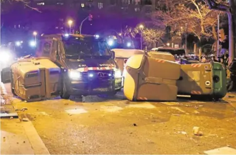  ?? REUTERS ?? Un vehículo de los Mossos atraviesa una barricada realizada con contenedor­es de basura en Barcelona