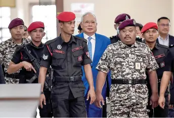  ?? — Bernama photo ?? Najib accompanie­d by security personnel upon arrival at the Kuala Lumpur High Court.