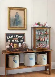  ??  ?? Left: An old bucket bench provides a multilevel display for eclectic treasures in the living room. The simplicity of the crocks on the lower shelf offsets the busyness of the year-round display of Santa Claus figures and the stuffed toys arrayed in a biscuit box. A pastel reproducti­on of an old family tintype graces the wall behind it.