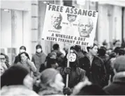  ?? NIKLAS HALLE’N/GETTY-AFP ?? A protester holds up a placard defending Julian Assange on Friday in London.