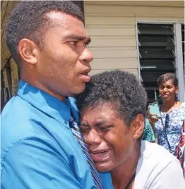  ??  ?? Cathrine Baleinagag­a is comforted by a comrade at the arrival of the body of the late Police Constable Siuta Niumataiwa­lu .