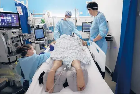  ?? KIRSTY WIGGLESWOR­TH/AP ?? Critical care staff looks after a COVID-19 patient at King’s College Hospital in London.