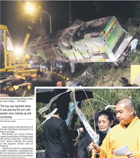  ??  ?? A bus that crashed along a highway is lifted by cranes in Taipei. — AFP photo A family member of the passengers on the crashed tour bus cries during a Taoist ceremony for the victims, on a highway in Taipei, Taiwan. — Reuters photo