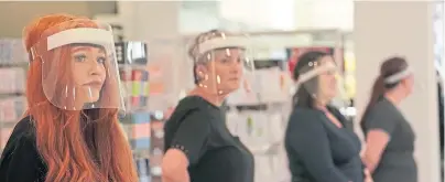  ??  ?? Shop staff in face masks wait to welcome back customers to the Fenwick store in Newcastle