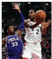  ?? AP/The Canadian Press/NATHAN DENETTE ?? Toronto forward Kawhi Leonard (right) scored 31 points on 10-of-19 shooting from the floor, including 2 of 5 three-pointers, to lead the Raptors to a 129-112 victory over the Philadelph­ia 76ers on Tuesday at the Scotiabank Arena in Toronto.