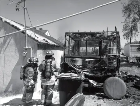  ?? SOMERTON/COCOPAH FIRE DEPARTMENT PHOTO ?? MEMBERS OF THE SOMERTON/COCOPAH FIRE DEPARTMENT look over what remains of a recreation­al vehicle that caught fire at a home in the 200 block of Capitol Street in Somerton on Thursday. A firefighte­r battles the flames (below).