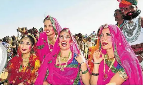 ??  ?? Bikaner: Foreign tourists wearing Indian attire at the 20th Internatio­nal Camel Festival 2013 in Bikaner yesterday.
PTI
