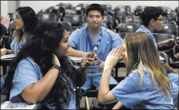  ?? JASON OGULNIK/LAS VEGAS REVIEW-JOURNAL ?? CampMED students Rania Mudassar Saeed, left, and Kimberly Giannanton­io observe the effects of light on pupil size during a session Friday at UNLV. Fifty 13- to 15-year-olds aspiring to health care careers participat­ed in the new three-day summer...