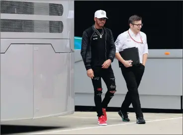  ?? Picture: JASON CAIRNDUFF, REUTERS ?? RACE-CAR ROCK STAR: Lewis Hamilton arrives for a drivers’ press conference at Silverston­e yesterday.